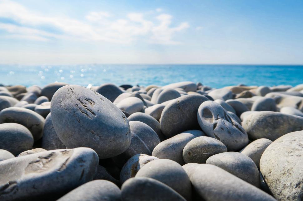 Free Image of Pebble beach under clear blue sky 