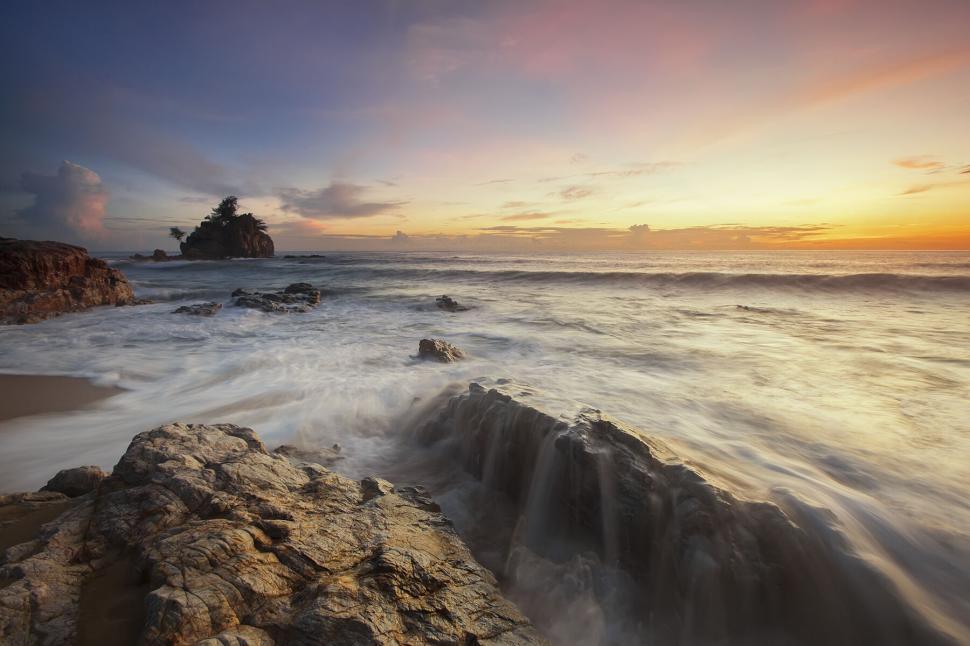 Free Image of Sunset over rocky beach with distant island 