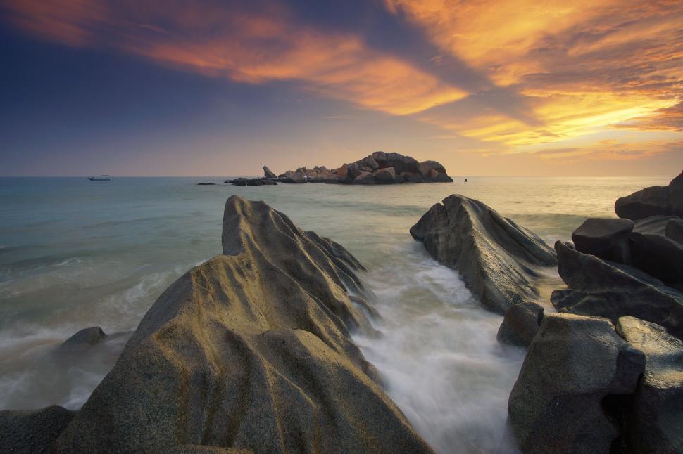 Free Image of Ethereal sunset over sculpted coastal rocks 