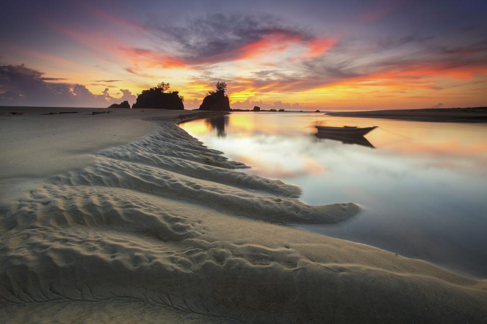 Free Image of Tranquil beach sunset reflecting on calm water 