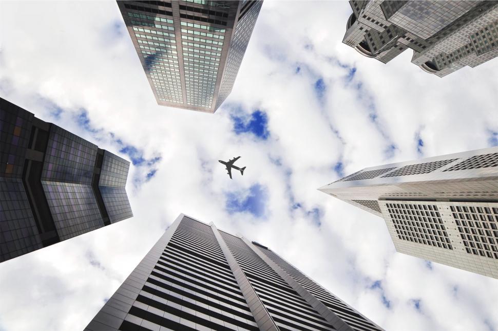 Free Image of Upward view of skyscrapers and airplane 