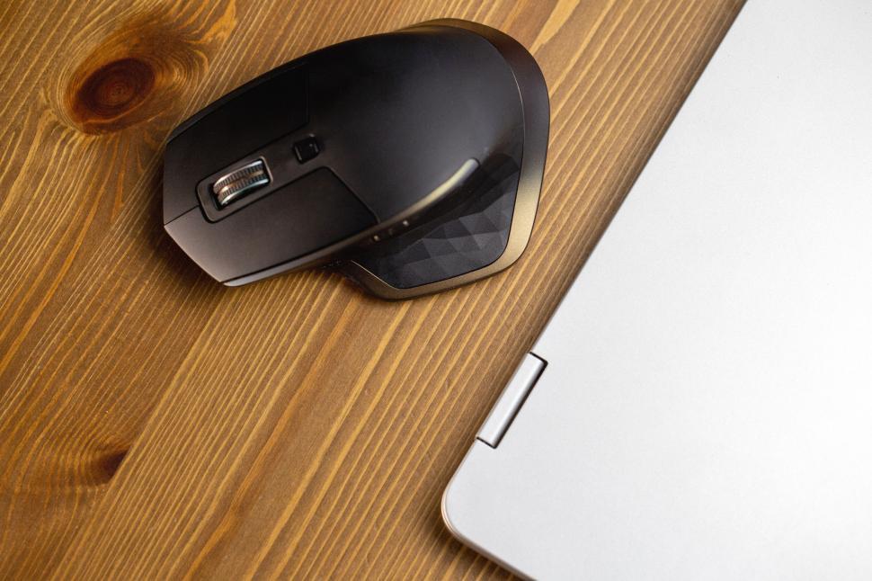 Free Image of Wireless mouse next to a laptop 