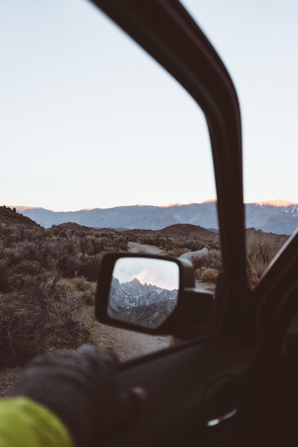 Free Image of Car mirror reflecting mountain scene 