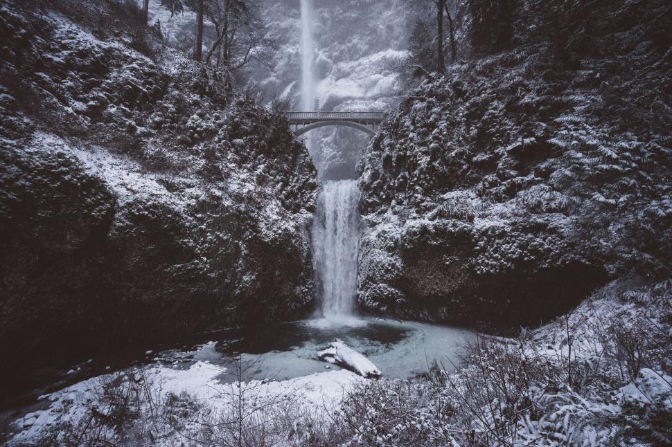 Free Image of Snow-covered bridge over a frozen waterfall 