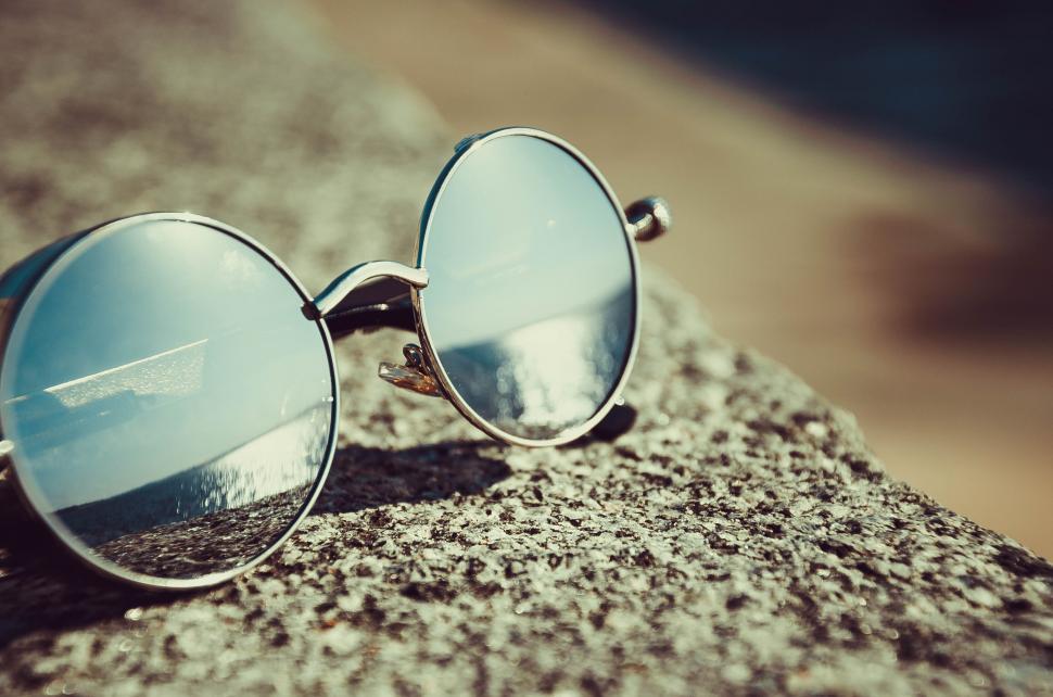 Free Image of Reflective sunglasses on stone surface 
