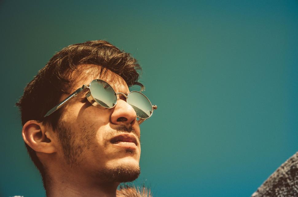 Free Image of Person with sunglasses outdoors with sky 