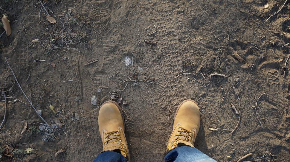 Free Image of POV of feet standing on a textured ground 