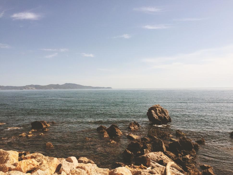 Free Image of Rocky coastline with clear water and mountains 