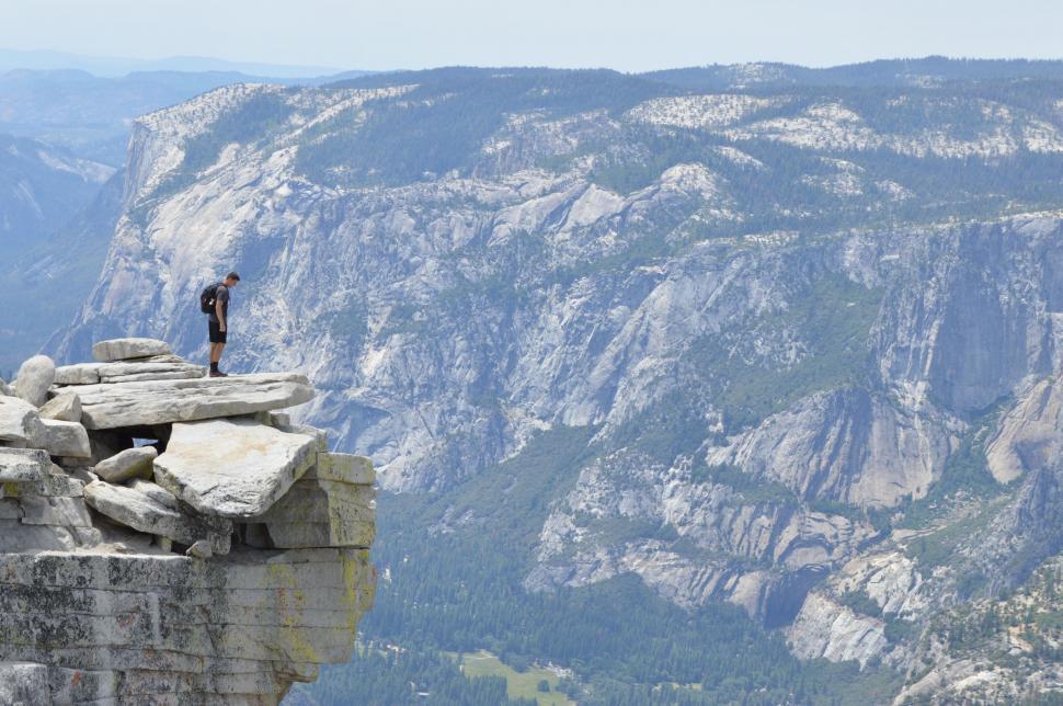 Free Image of Person standing on mountain ledge 