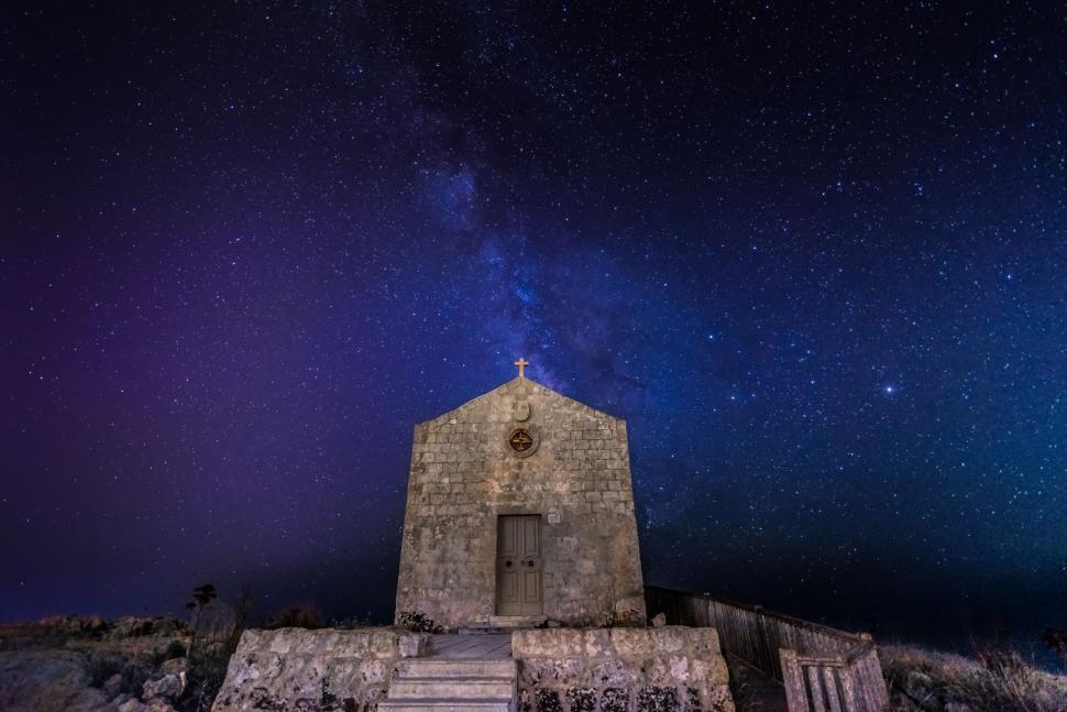 Free Image of Starry night sky over a stone chapel 