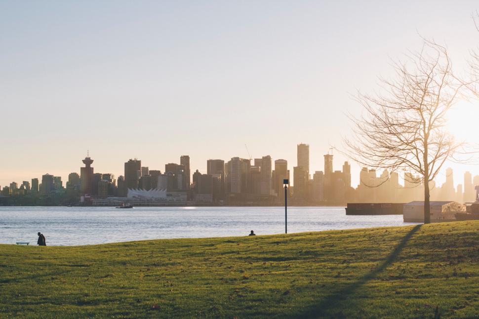 Free Image of Sunset view of a city skyline from a park 