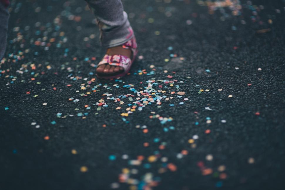 Free Image of Child walking on confetti-covered street 