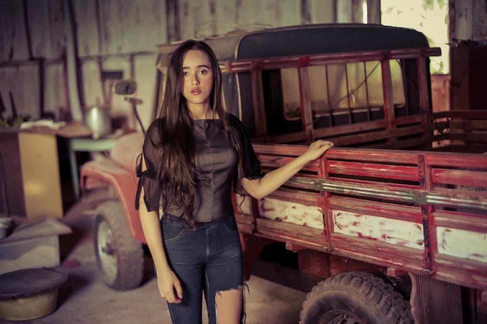Free Image of Woman posing with a vintage truck indoors 