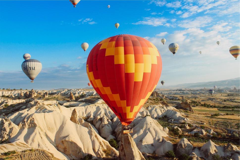 Free Image of Hot air balloons flying over rocky landscape 