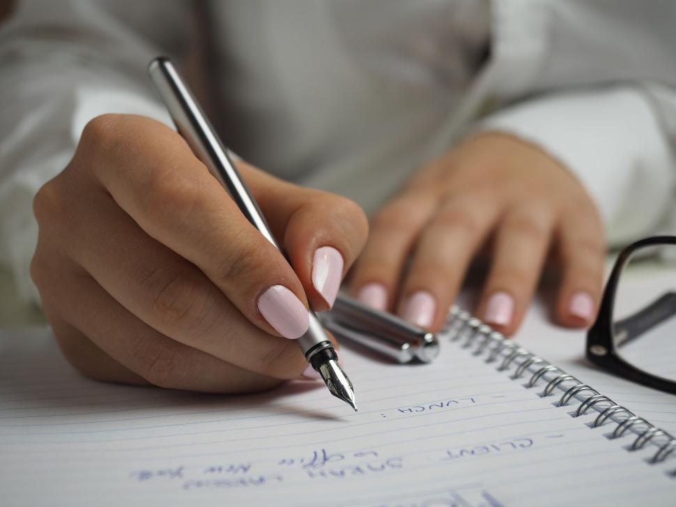Free Image of Close-up of woman writing in notebook 