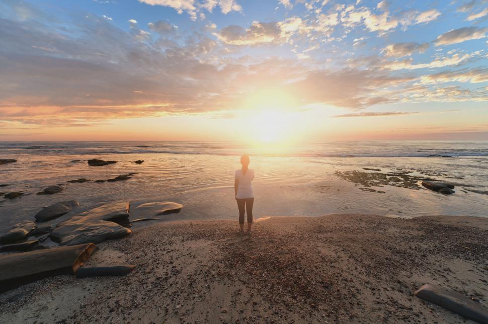Free Image of Sunset silhouette of a person on the beach 