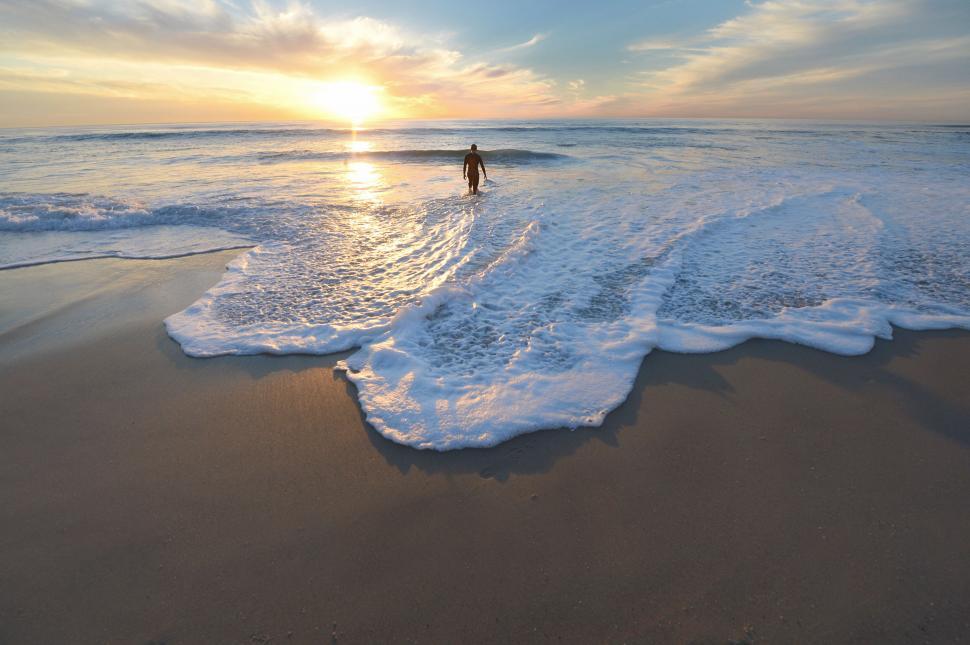 Free Image of Surfer entering the ocean waves at dawn 