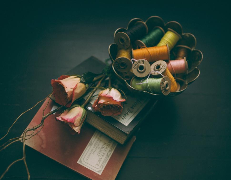 Free Image of Vintage sewing items and dried roses on table 