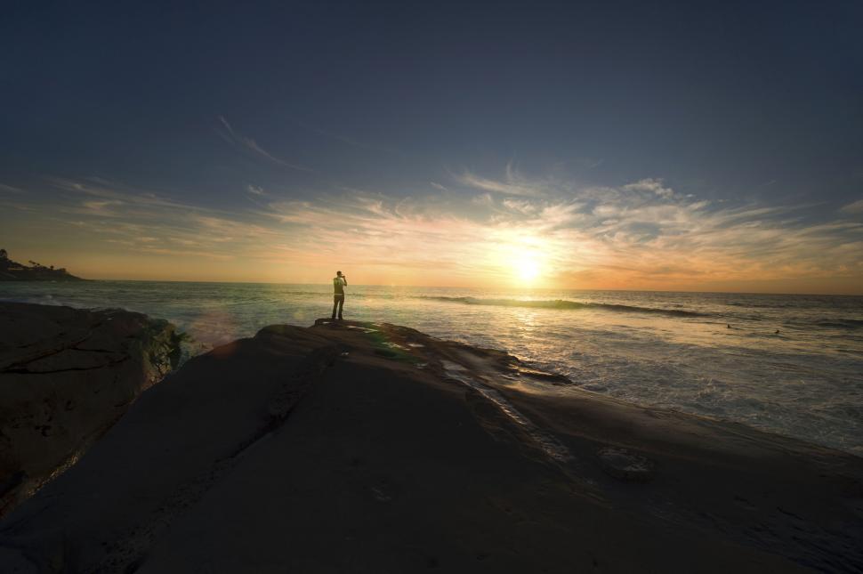 Free Image of Sunset view with silhouette person on cliff 