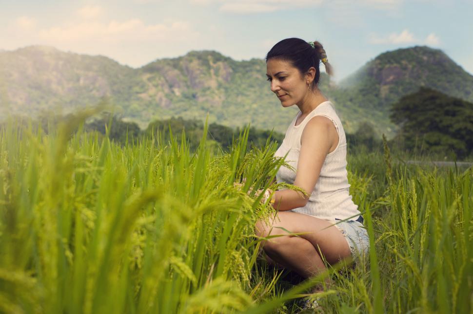 Free Image of Woman meditating in a green paddy field 