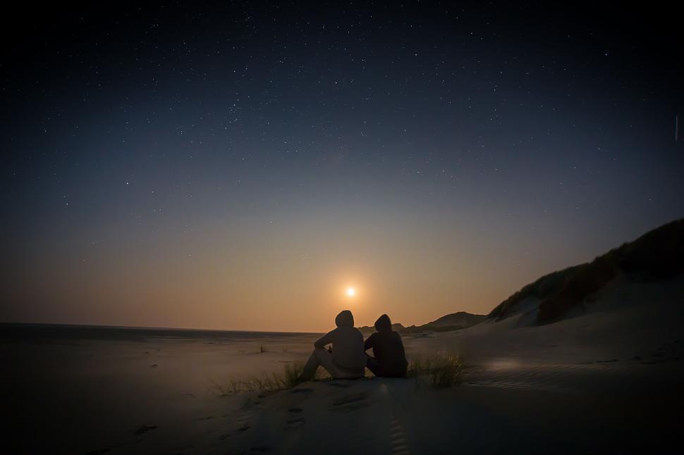 Free Image of Couple enjoying a moonlit beach night 