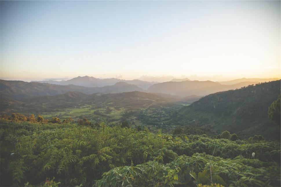 Free Image of Sunrise over a lush green valley 