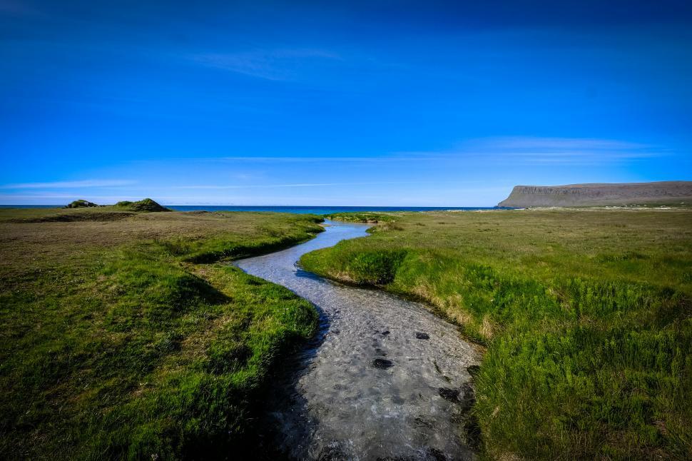 Free Image of Serpentine river meandering through green plains 