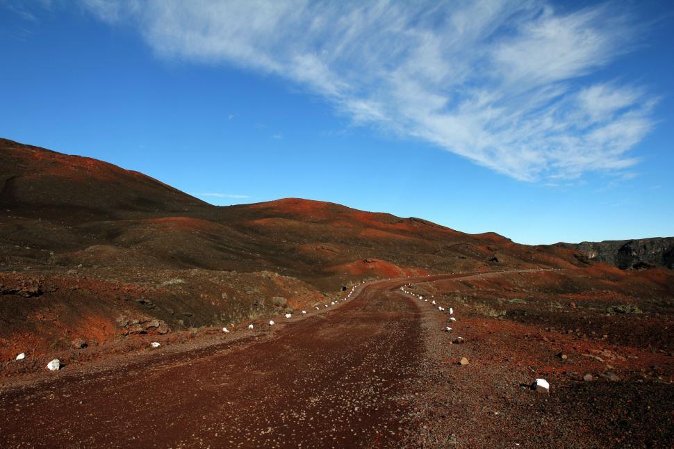 Free Image of Red dirt road under a clear blue sky 