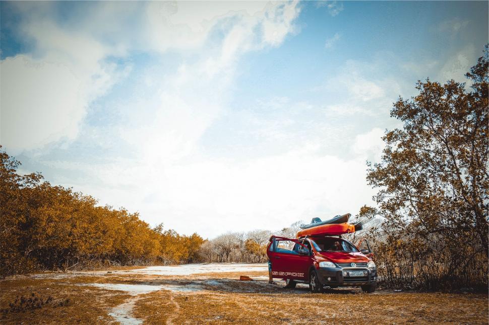 Free Image of Red vehicle with kayaks parked outdoors 