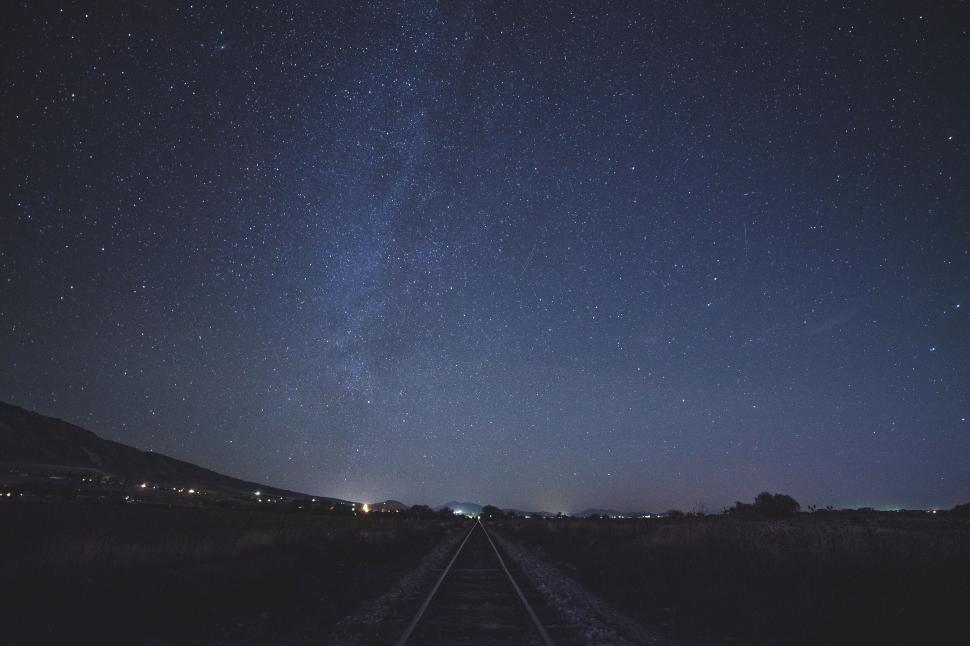 Free Image of Starry night sky over railroad tracks 