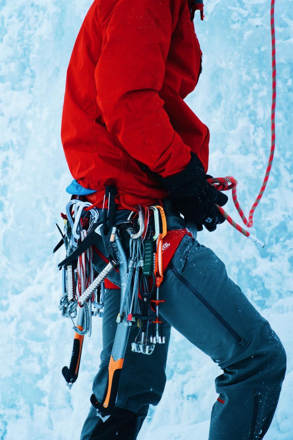 Free Image of Mountaineer preparing equipment in snowy terrain 