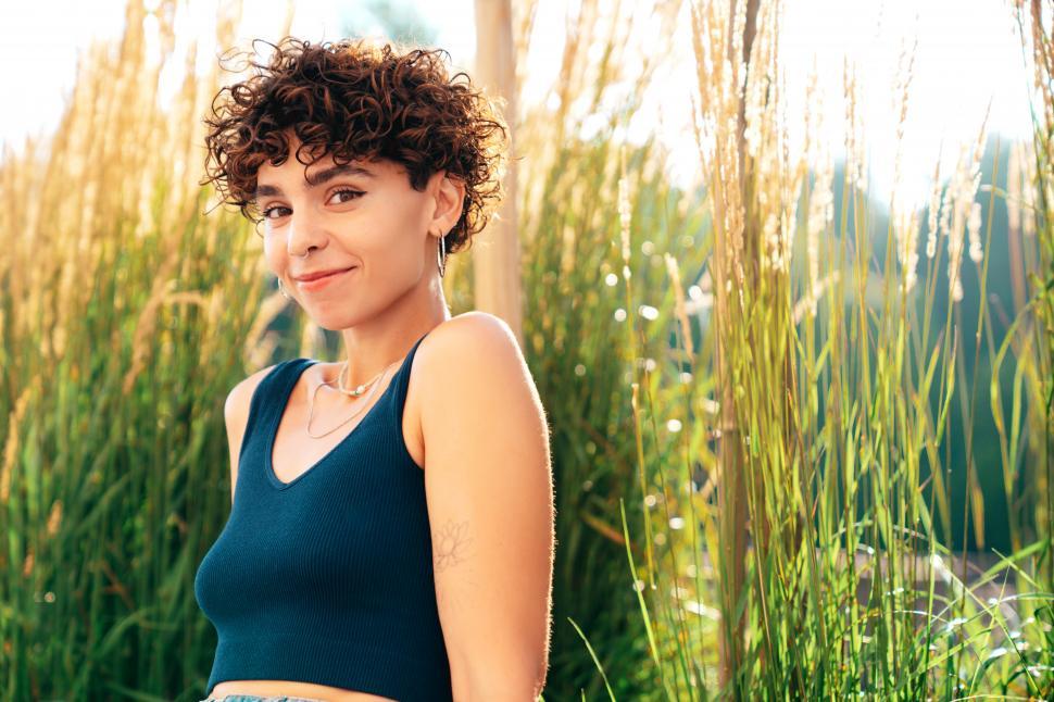 Free Image of A woman smiling in front of tall grass 