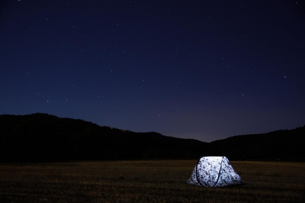 Free Image of Boulder illuminated under starry night sky 