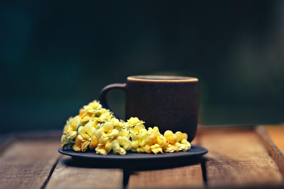 Free Image of Cup of coffee with golden flowers on side 