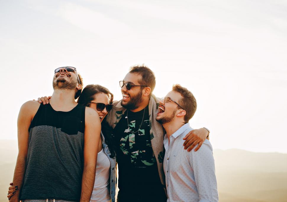 Free Image of Friends embracing and laughing at sunset 