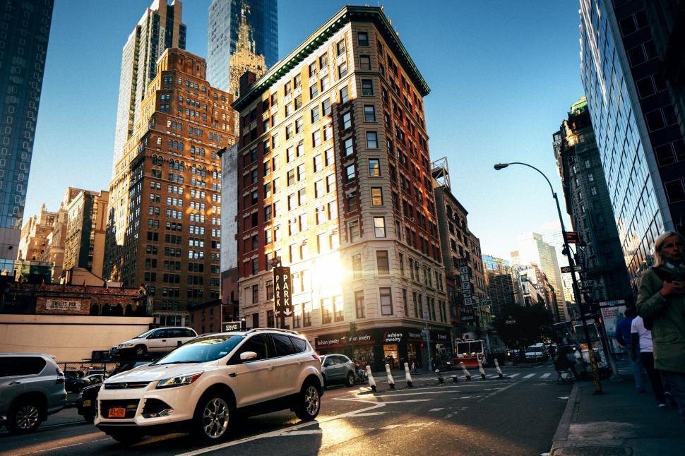 Free Image of City intersection with cars and pedestrians 