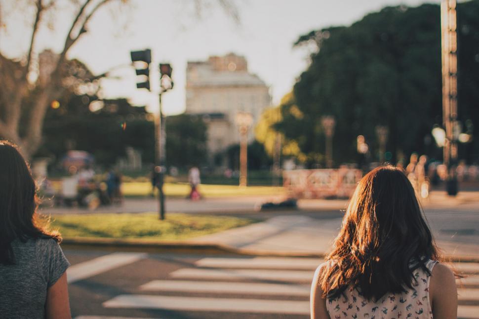 Free Image of Two women walking near city park 