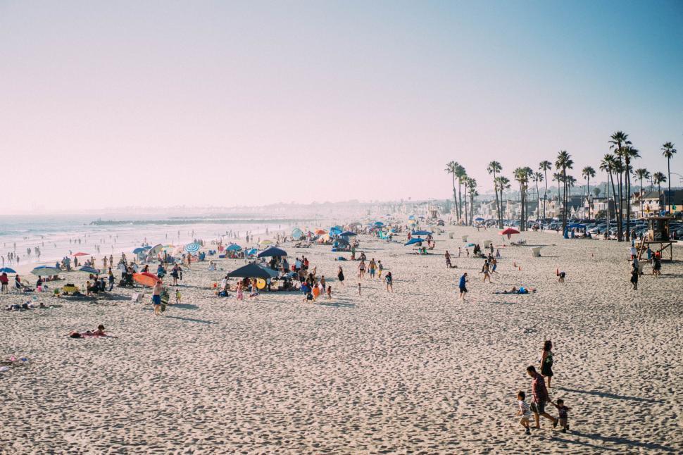 Free Image of Crowded beach with multiple beachgoers 