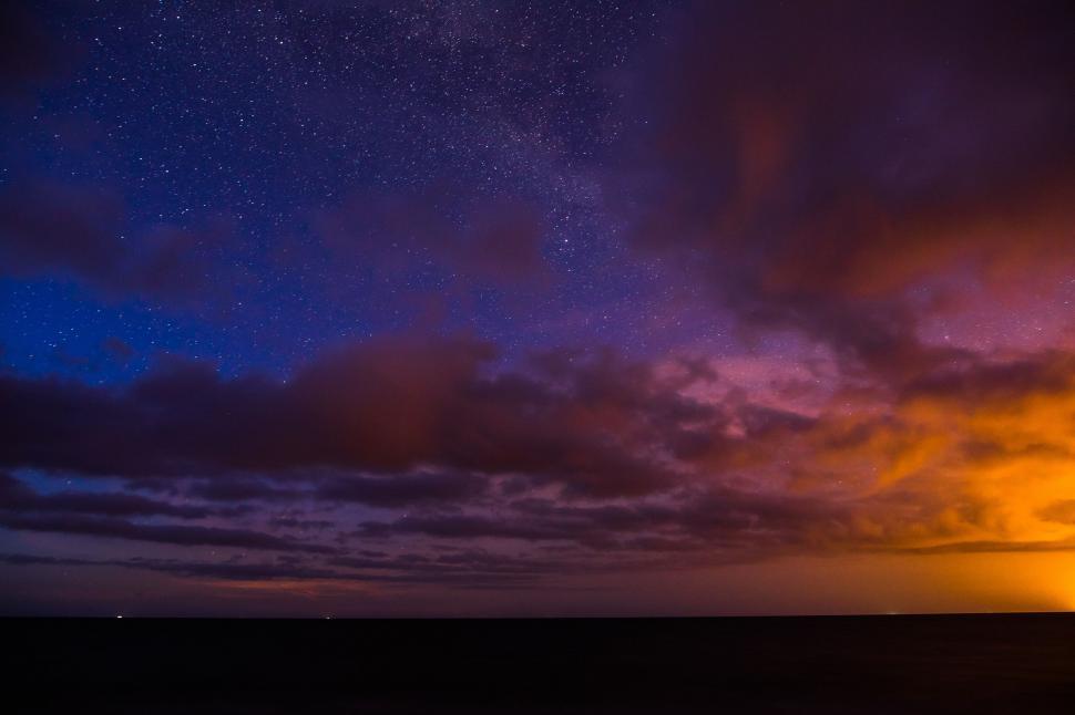 Free Image of Starry night sky with colorful sunset clouds 