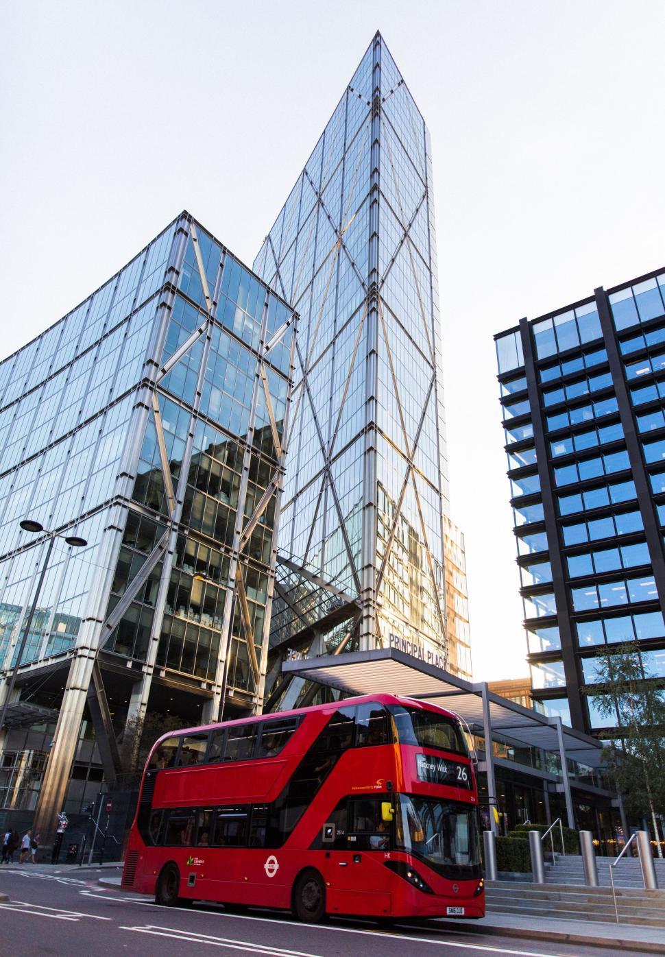 Free Image of Modern glass building with red double-decker bus 
