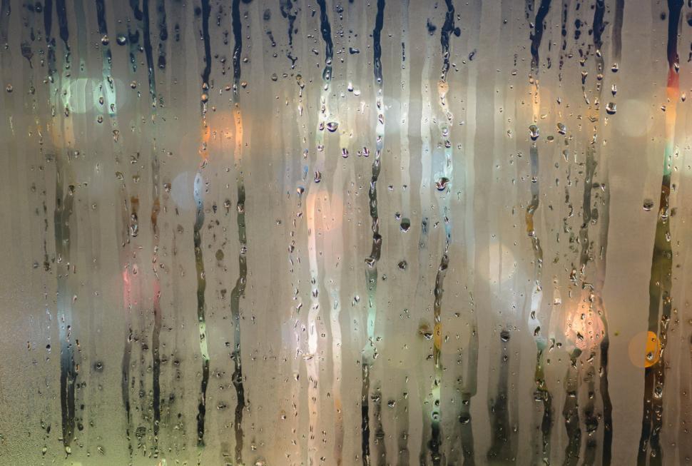 Free Image of Raindrops on window with city lights 
