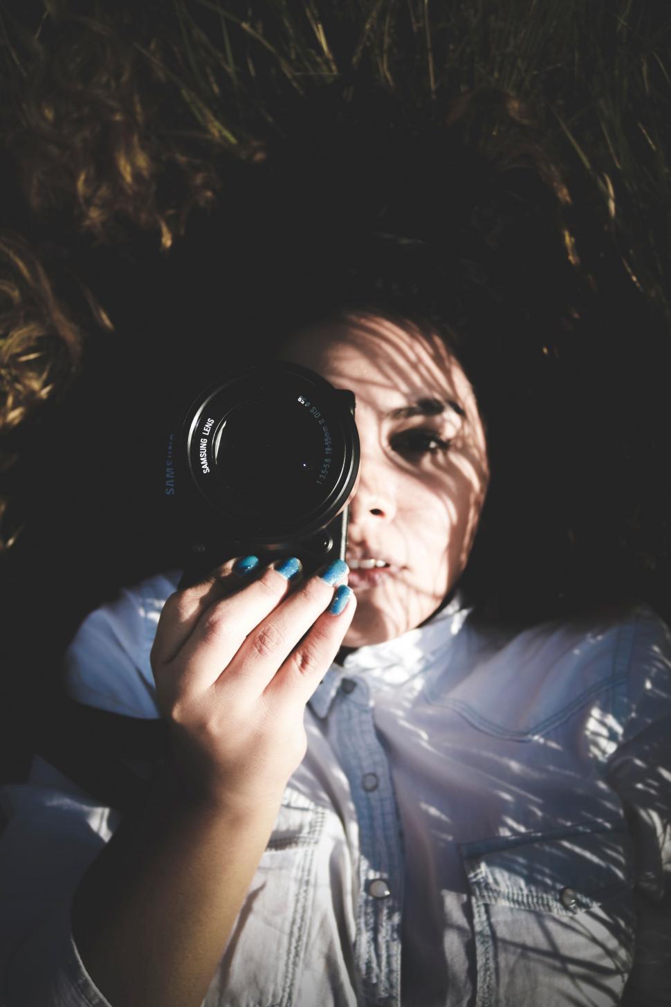 Free Image of Person lying on grass holding camera 