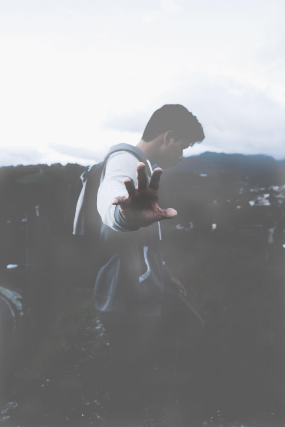 Free Image of Person with Obscured Face Extending Hand 