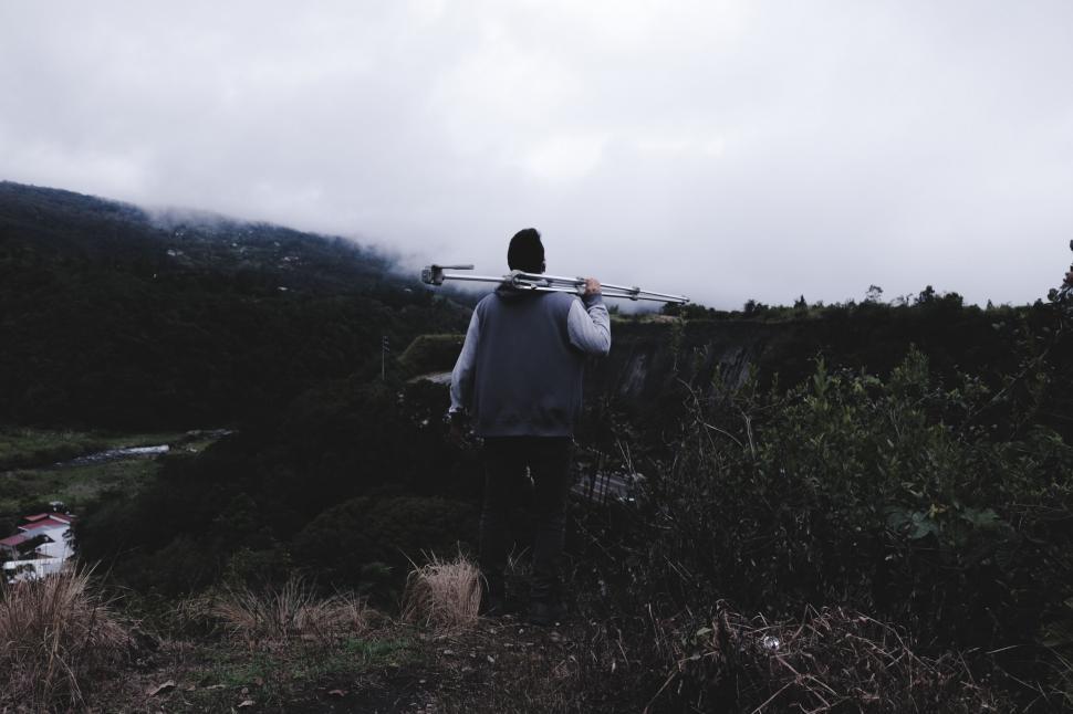 Free Image of Person Carrying Tripod on a Mountaintop 