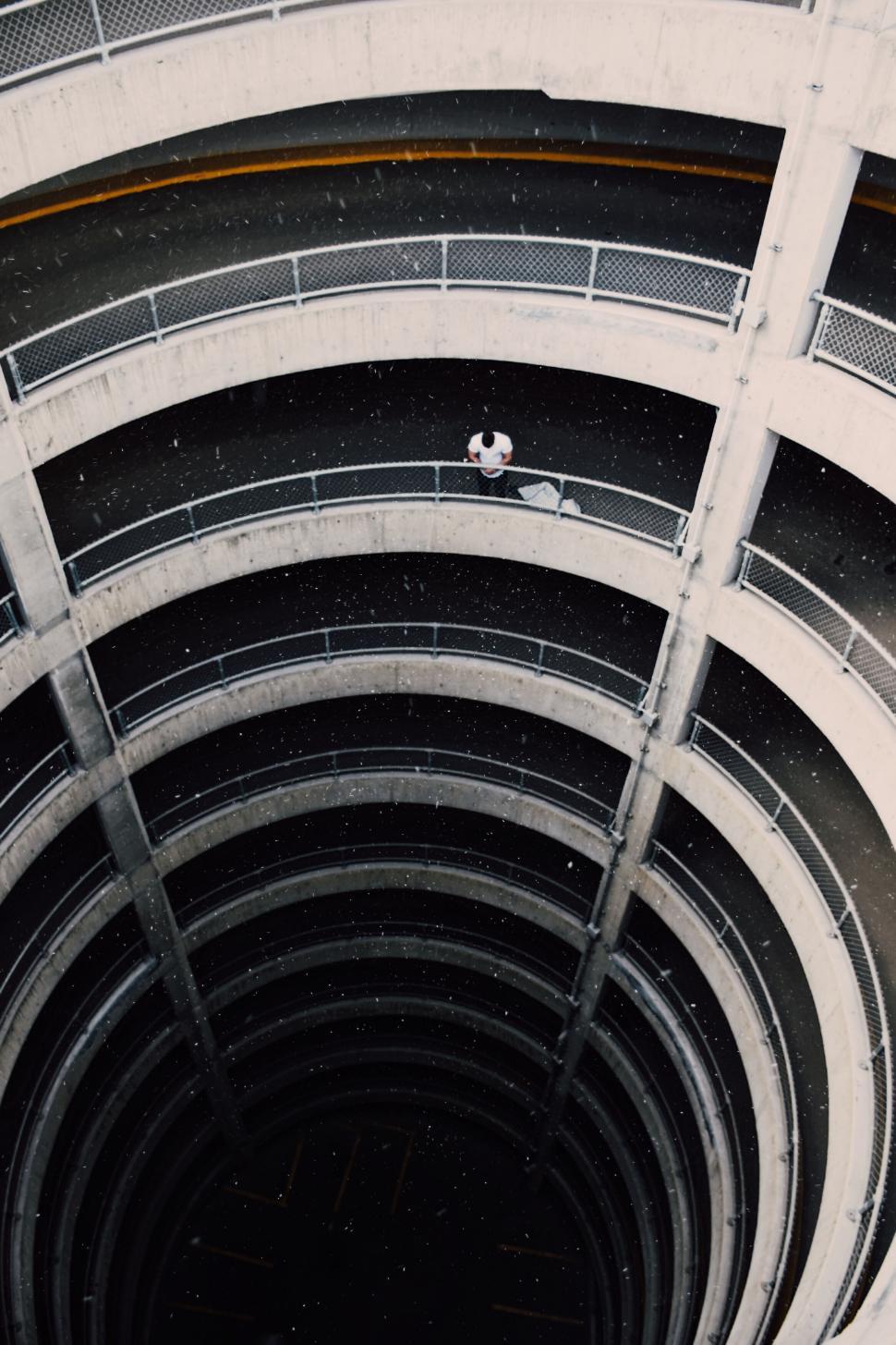 Free Image of Person sitting in a circular parking garage 
