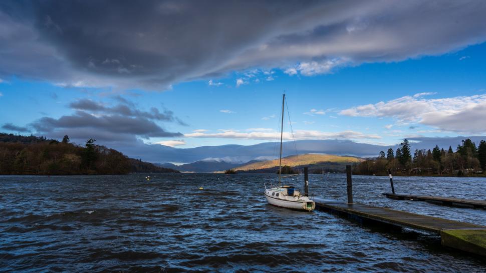 Free Image of Sailboat docked on a windy lake 