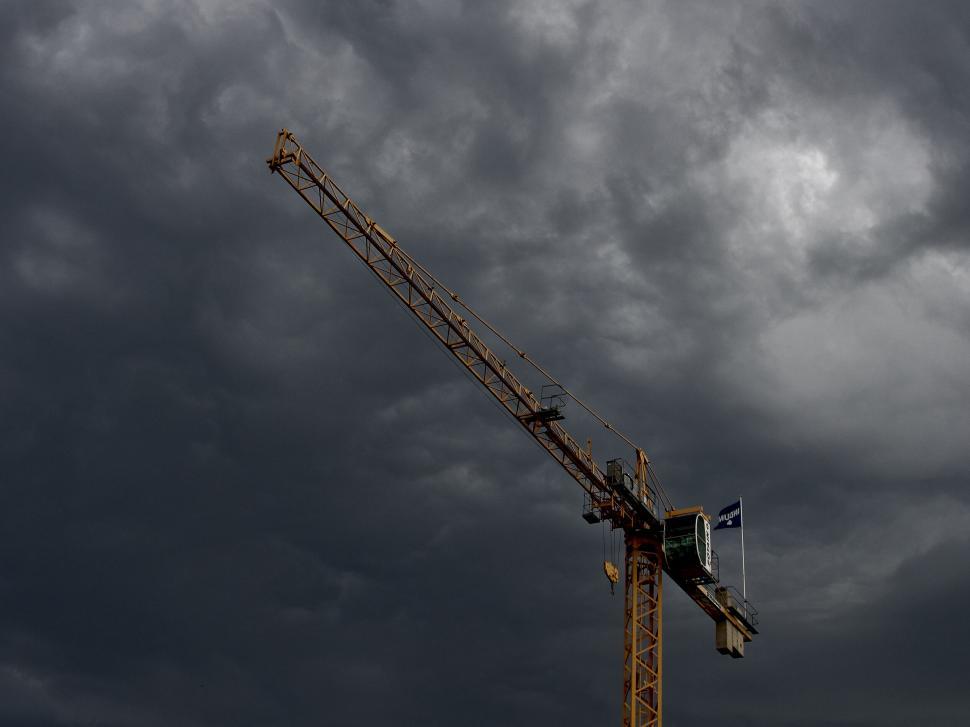 Free Image of Tower crane against dark stormy clouds 