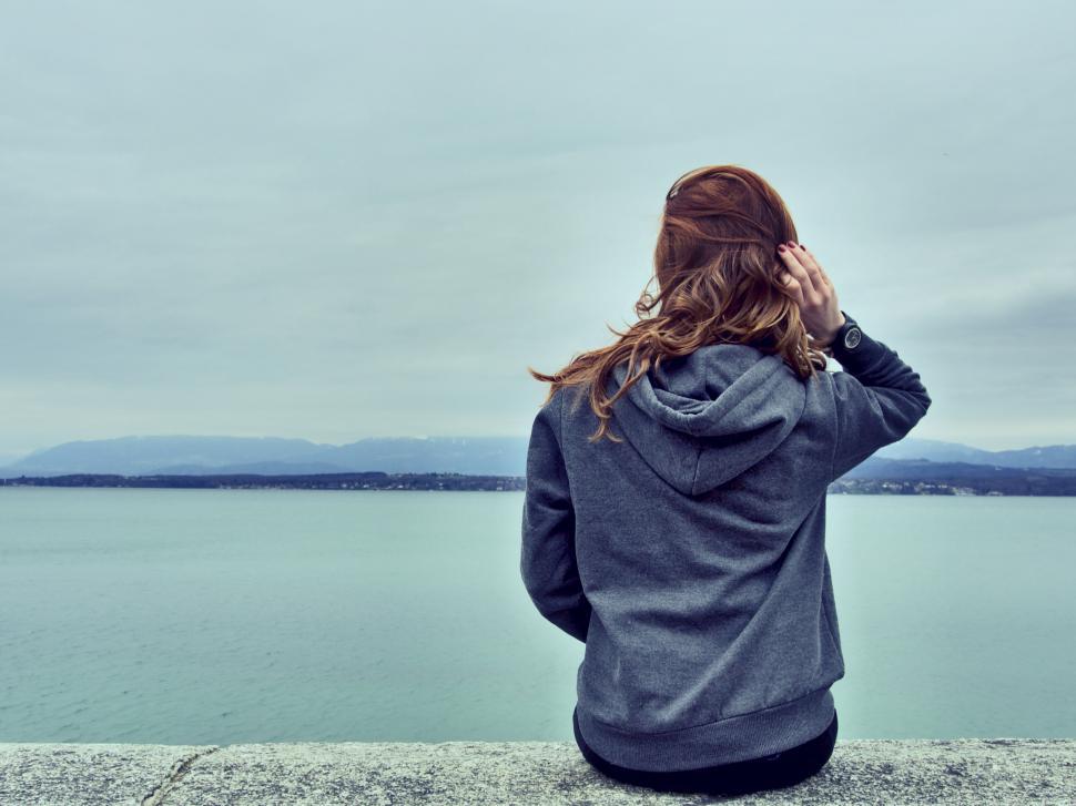 Free Image of Woman gazing at the sea from a pier 