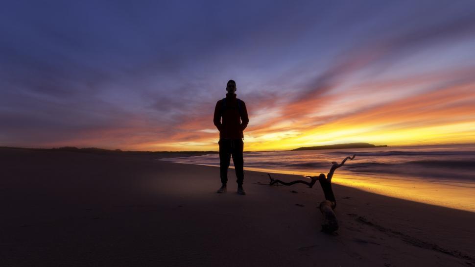 Free Image of Silhouette of a person on a beach at sunset 