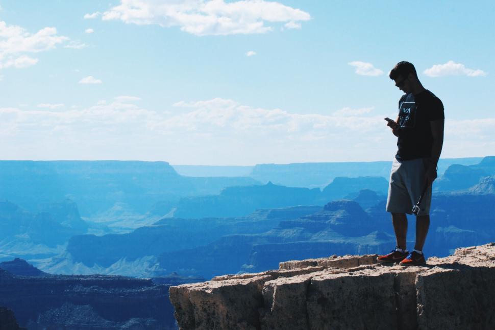 Free Image of Man standing on edge overlooking the Grand Canyon 